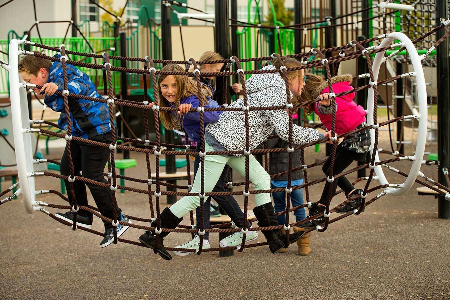 Image of a group of children running through a bridge made of net