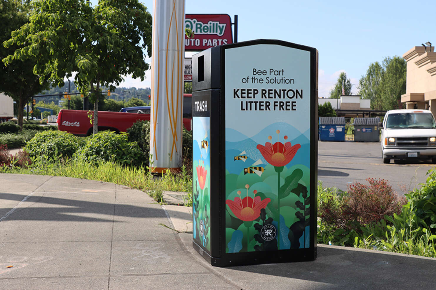 Black plastic trash receptacle with flower images printed on each side with the caption, 