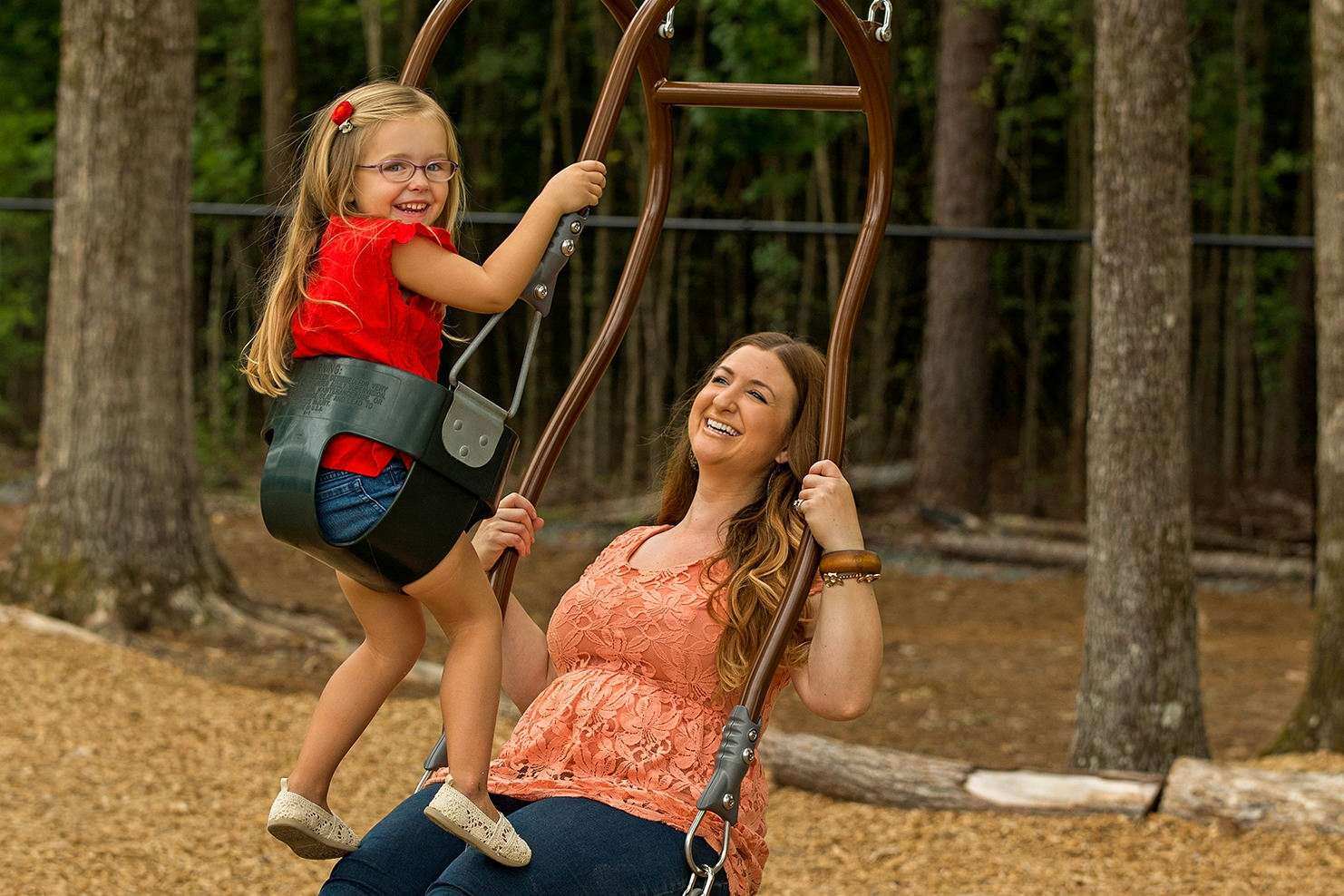 Image of a child and woman riding on an expression swing together