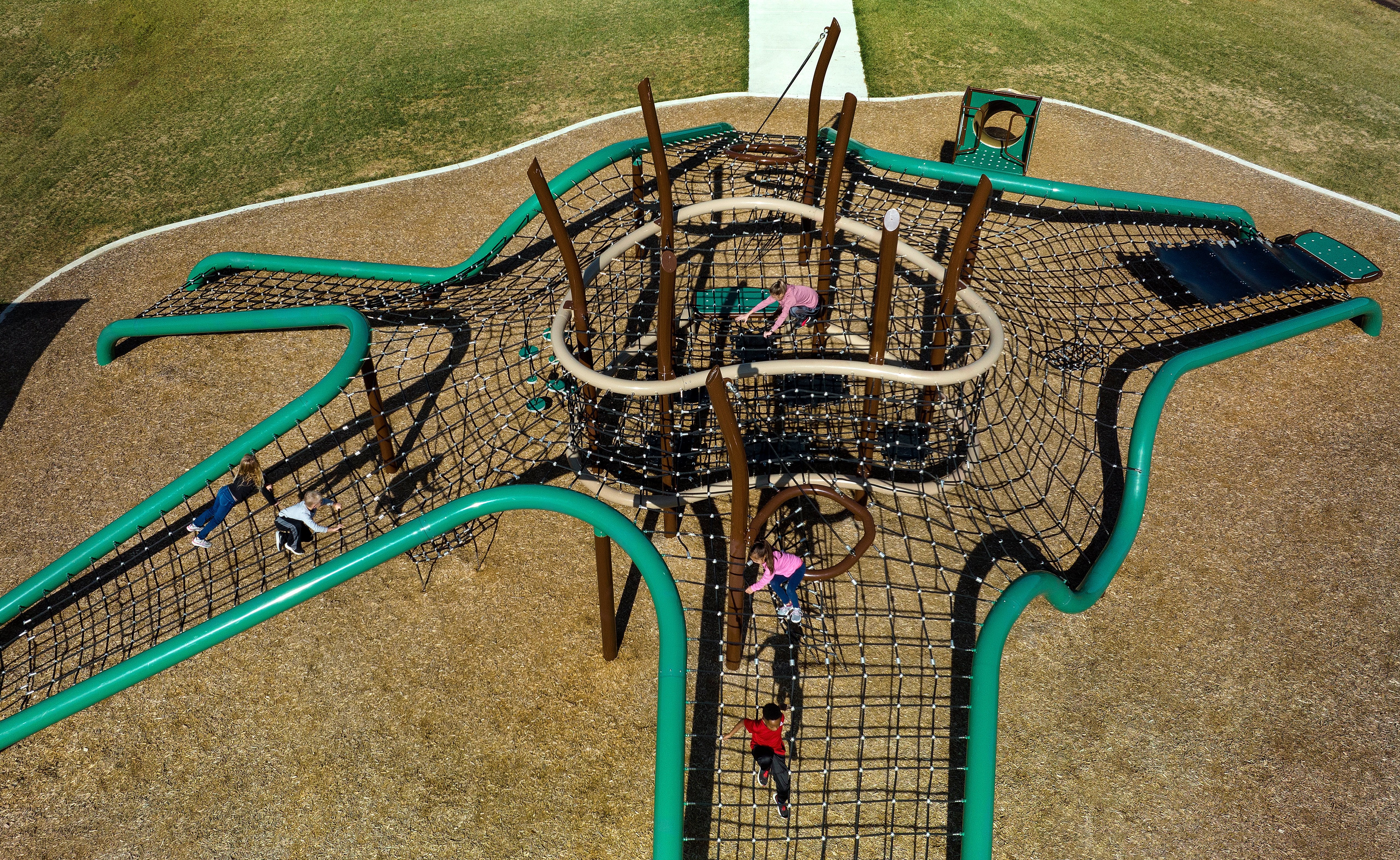 Image of a group of children climbing across a net bridge