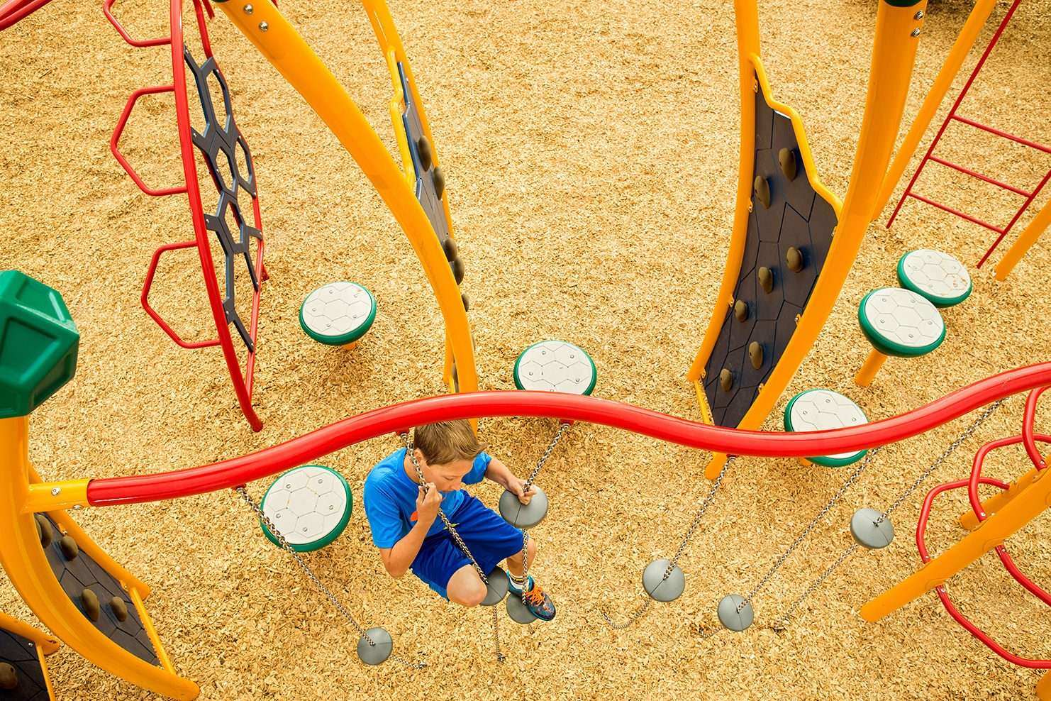 Image of a child maneuvering across circular pads connected to a bar