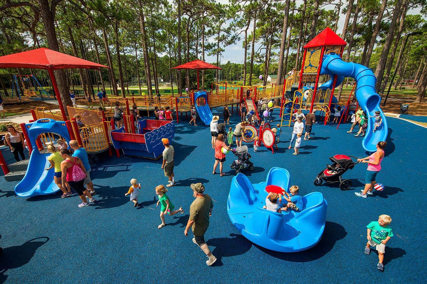 Image of an array of people looking and playing on a blue playground