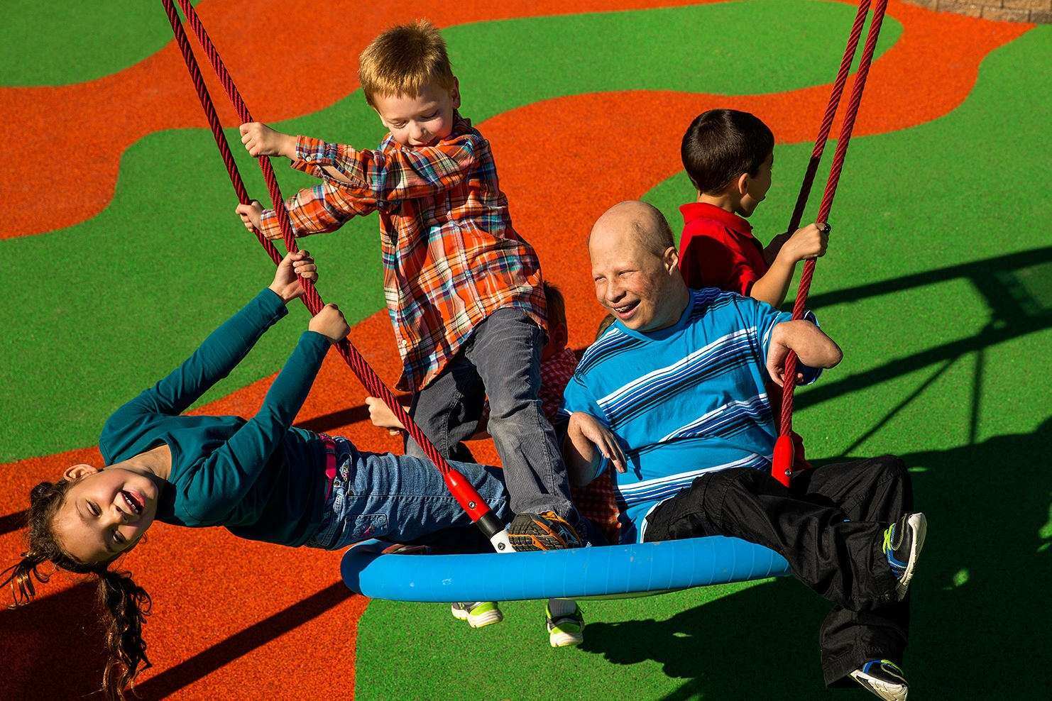 Image of a group of children playing on a swing together