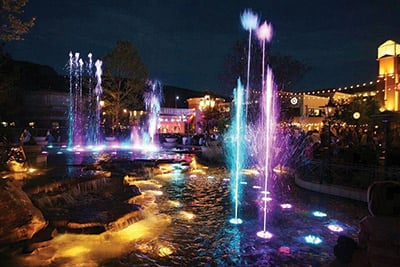 a nightime view of colorfully lit fountains