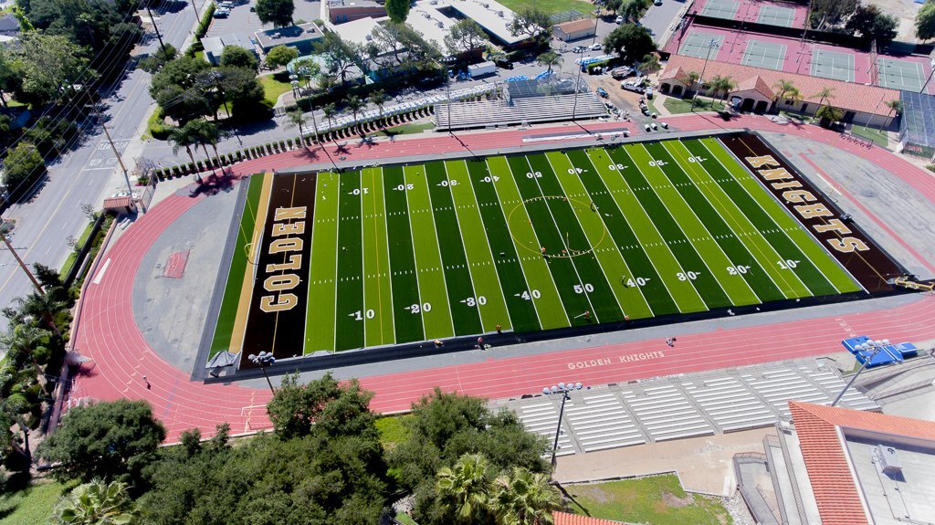 large turf football field with golden knights written across both end zones