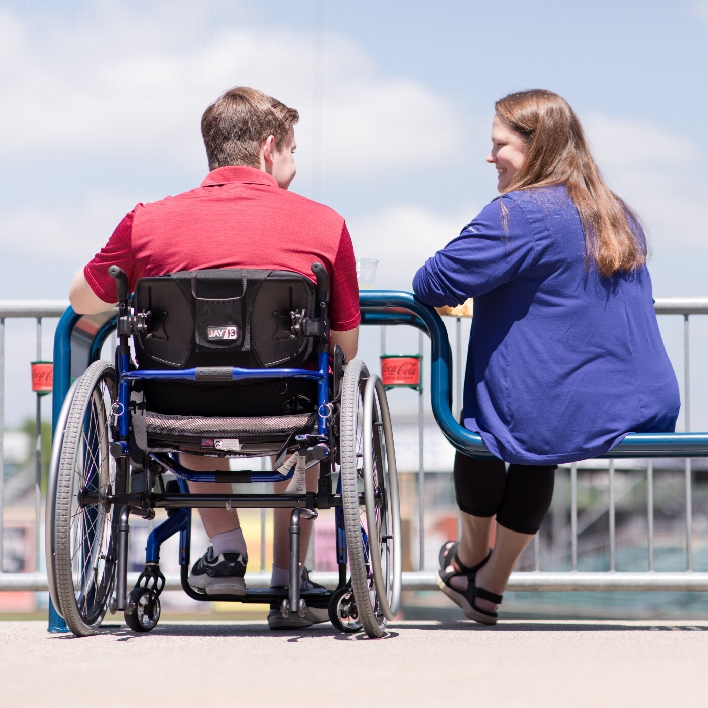 Image of a man in a wheelchair and a woman talking to one another