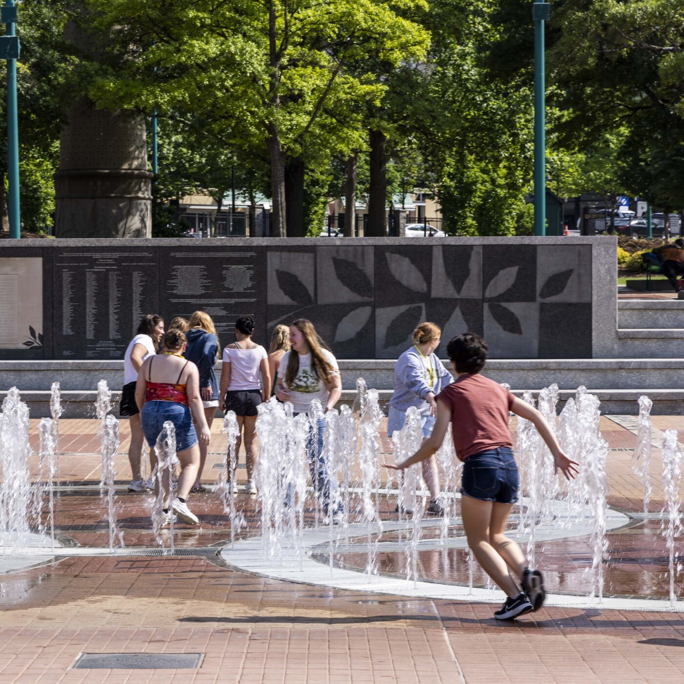 Image of a group of children running through fountains at a water play park