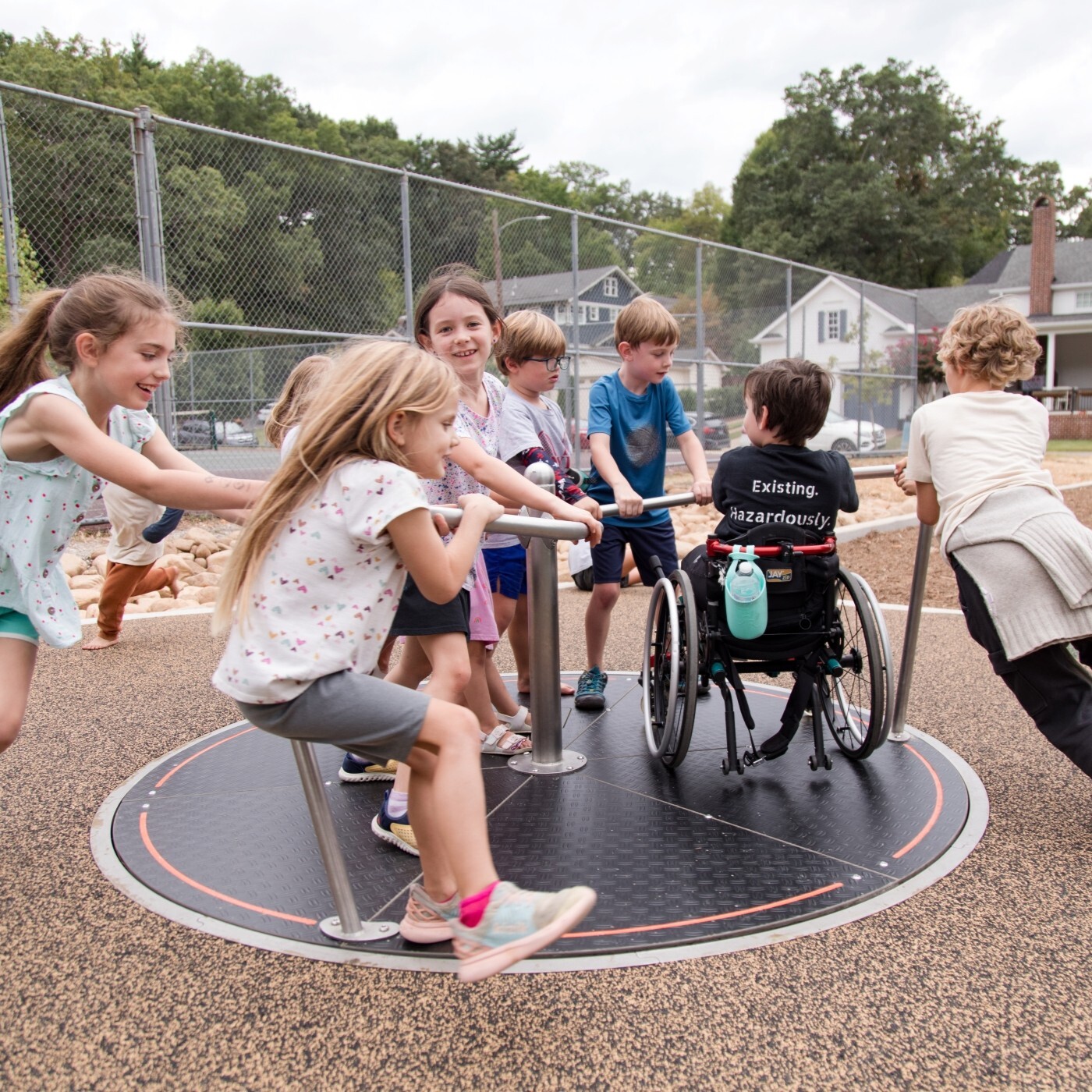 Image of a group of children pushing a playground carousel