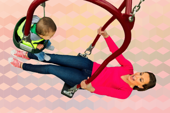 A smiling mother and baby swing together on an expression swing.