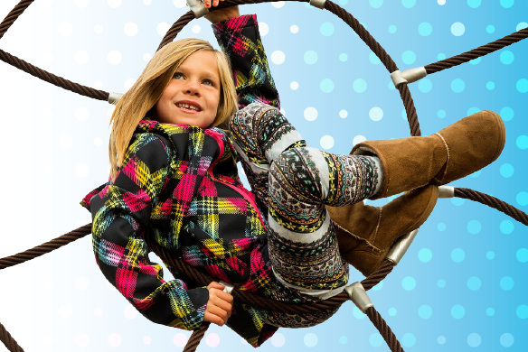 A young girl in a multicolored coat sitting inside of a rope circle equipment