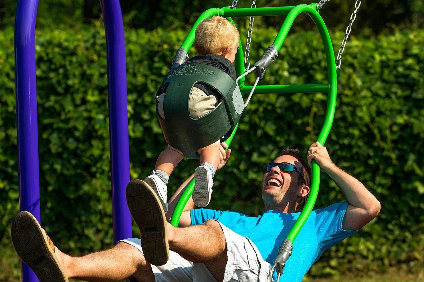 Image of a man and baby swinging on an expression swing together