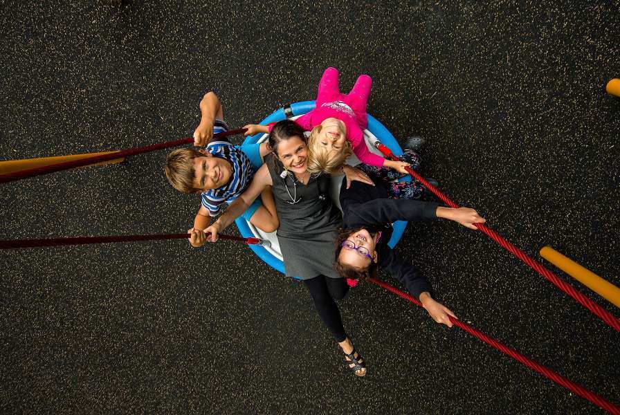 A woman and three children on a swing as seen from above