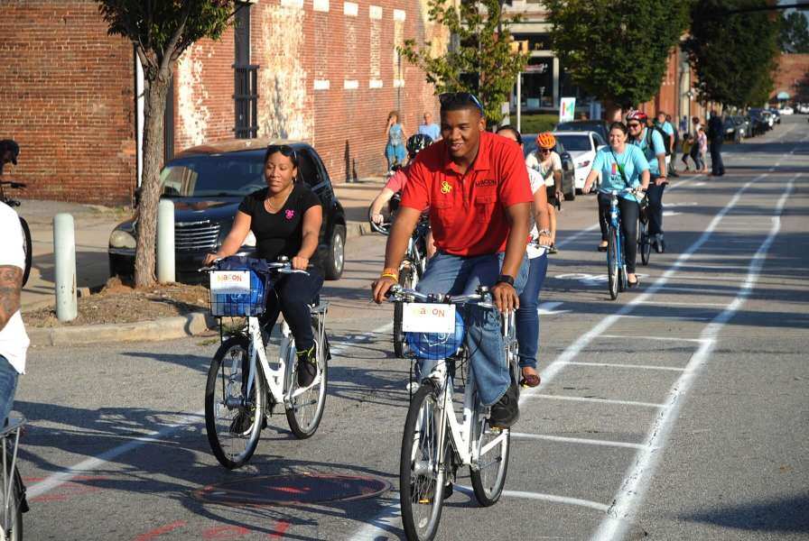 Group of people riding bikes on city street in bike lane.