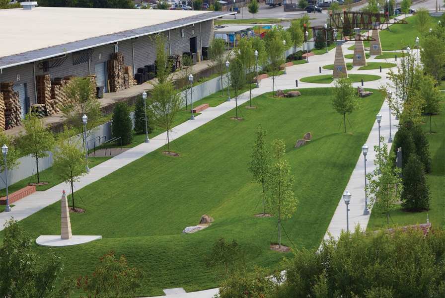 An overhead image of a large grassy area next to a two-story building