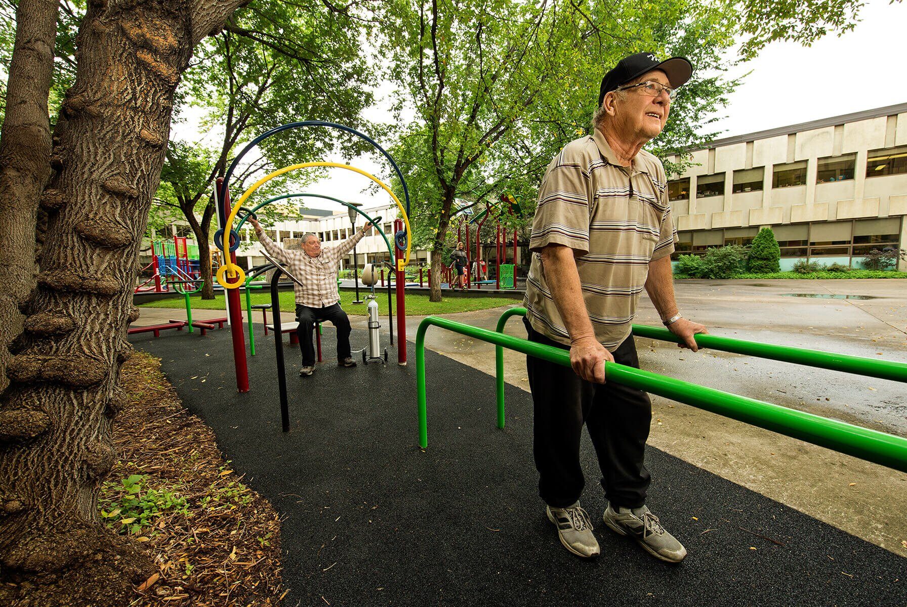 A pair of elderly men using outdoor adult exercise equipment