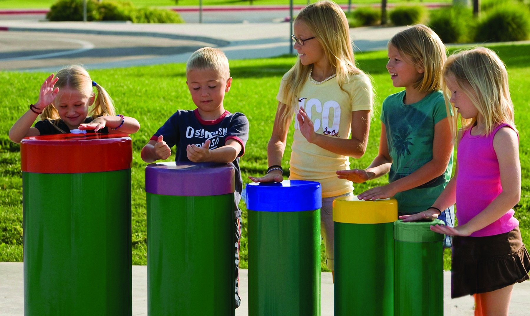 A group of children playing with a tuned drums park installation