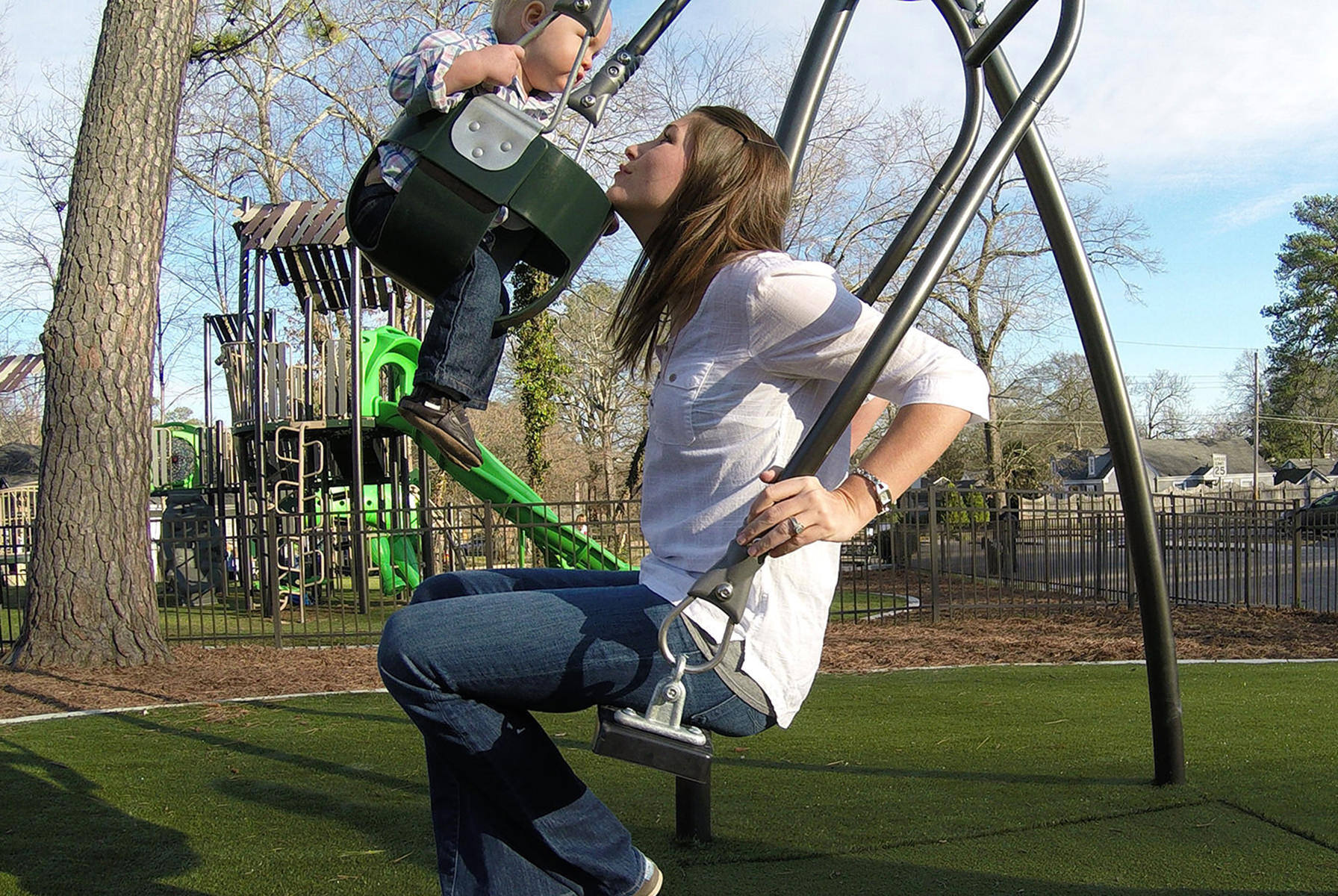 A woman and a baby swinging on the "expression swing" facing one another