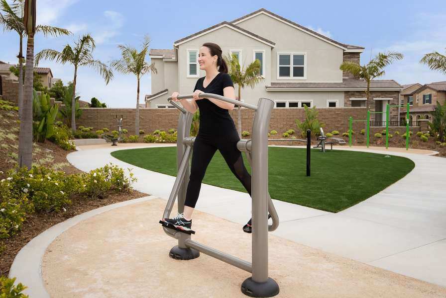 A woman on an outdoor elliptical machine 